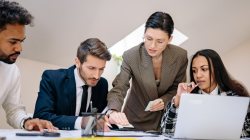 Quatro pessoas em volta de uma mesa falando como um fornecedor de folha de pagamento pode ajudar