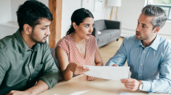 Três pessoas em uma mesa falando sobre como a gestão de benefício apoia o RH