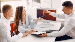 People buying a car. Beautiful woman in a white blouse. Manager working in a office.