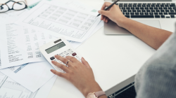 Imagem de duas mãos escrevendo em papéis como reduzir custos folha de pagamento