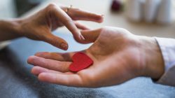 homem-dar-ornamento-vermelho-coracao-para-mulher