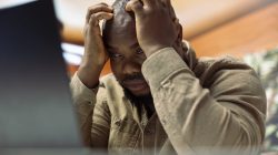 Stressed businessman trying to meet deadline for accounting work, feeling under pressure from his home office setup. Entrepreneur is overworked working on financial planning.